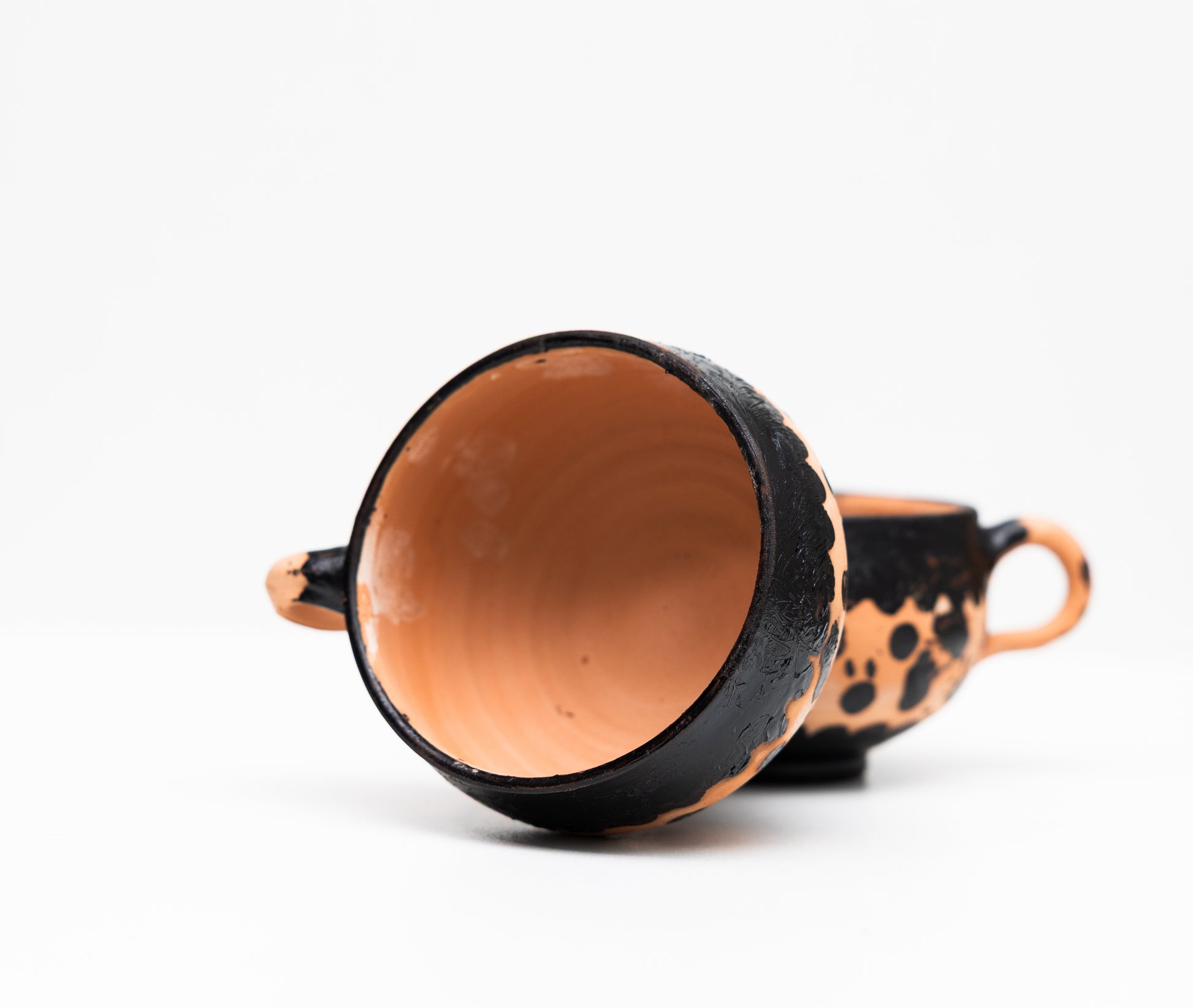 Tasse artisanale noire en terre cuite, fabriquée à la main, mettant en avant l'artisanat marocain et la poterie marocaine.