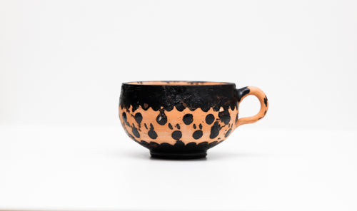 Tasse artisanale noire en terre cuite, fait main au Maroc, mettant en valeur l'artisanat marocain.